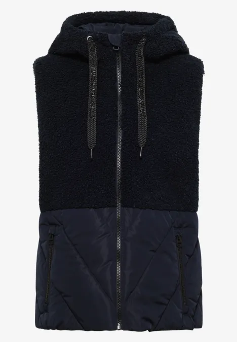 Gilet sans manches bleu foncé avec haut en polaire Teddy, bas matelassé, capuche et fermeture éclair.