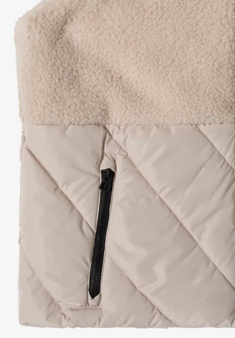 Veste beige avec surface en polaire, partie inférieure matelassée et poche zippée noire.