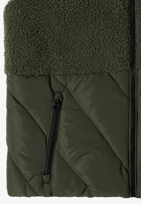 Tissu matelassé vert avec insert en sherpa et poche zippée.
