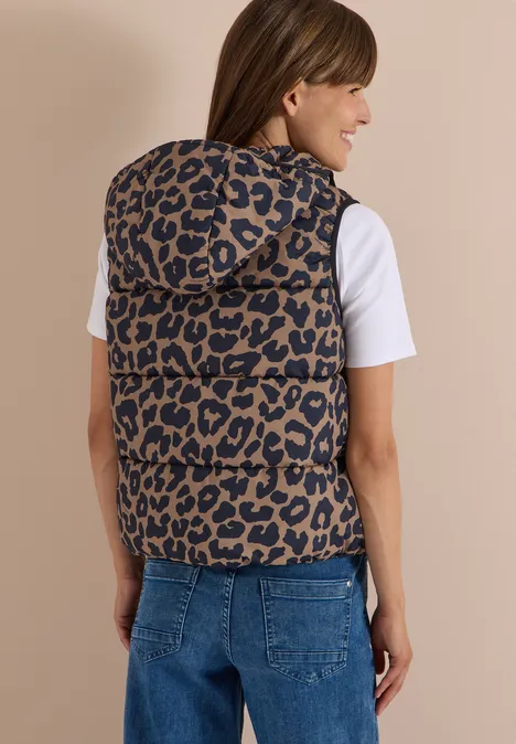 Gewatteerd vest met capuchon en zakken creamy mocha Vrouw van achteren in jeans en wit T-shirt draagt mouwloze gewatteerde bodywarmer met luipaardprint en capuchon.