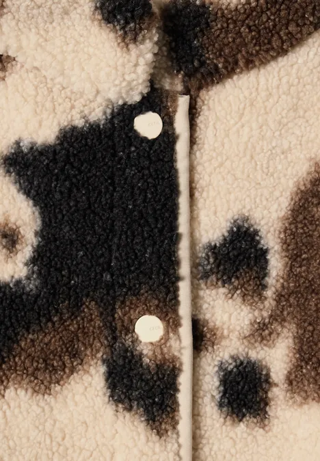 Beige-schwarze Teddyfleece-Jacke mit Fleckenmuster und Metall-Druckknöpfen, texturiert und kuschelig.