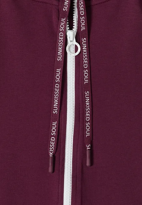 Kurzarm Sweatjacke mit Zipper sweet grape red Nahaufnahme eines bordeauxfarbenen Hoodies mit weißem Reißverschluss und Kordeln mit Aufdruck SUNKISSED SOUL