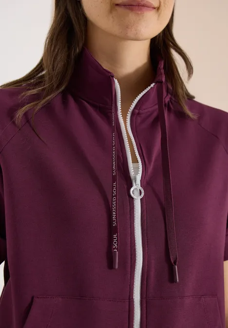 Kurzarm Sweatjacke mit Zipper sweet grape red Bordeauxfarbene Damenjacke mit kurzem Arm, hohem Stehkragen, weißem Reißverschluss und schwarzen Kapuzenkordeln.