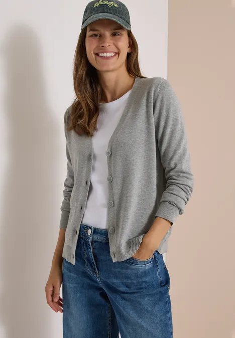 Cardigan mit V-Neck und Knopfleiste mineral grey melange Junge Frau mit grauem Cardigan, weißem T-Shirt, blauen Jeans und Baseballcap lächelt entspannt.