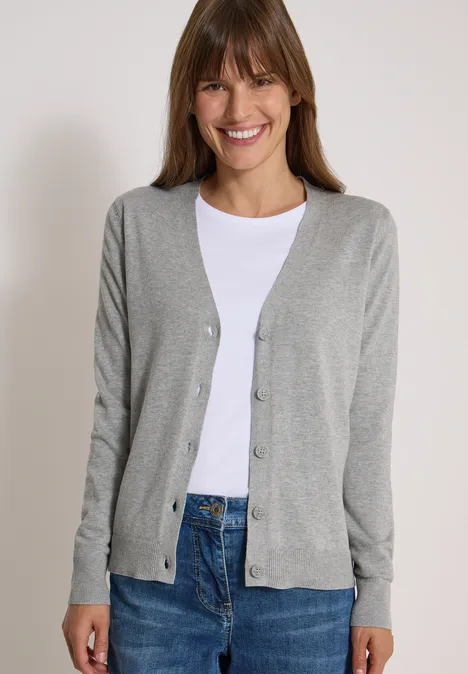Cardigan mit V-Neck und Knopfleiste mineral grey melange Frau mit hellem Cardigan, weißem Shirt und Jeans lächelt vor hellem Hintergrund.