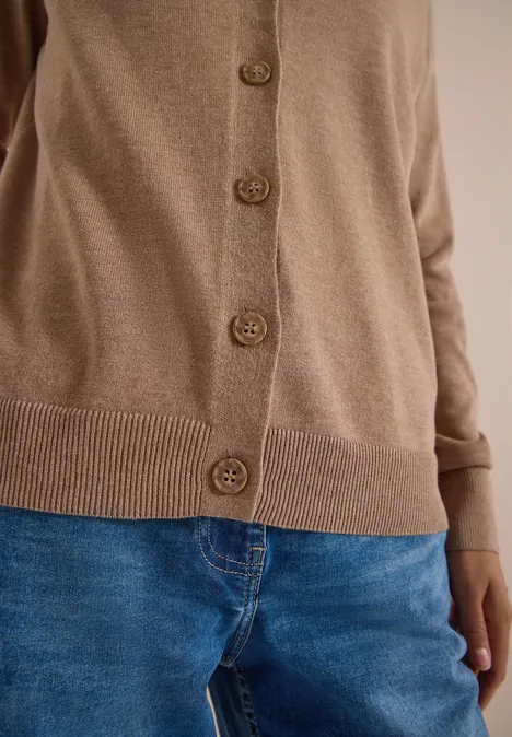 Vest met V-hals en knoopsluiting creamy mocha melange Beiger Cardigan mit Knöpfen kombiniert mit blauen Jeans.