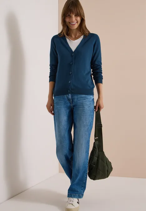 Cardigan mit V-Neck und Knopfleiste moonlight blue Frau in blauem Cardigan, Jeans und weißem Shirt hält grüne Tasche vor hellem Hintergrund.