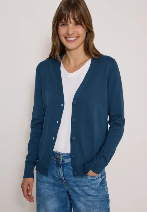 Cardigan mit V-Neck und Knopfleiste moonlight blue Eine Frau trägt einen blauen Cardigan, weiße Bluse und Jeans, lächelt vor hellem Hintergrund.