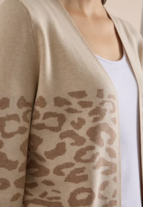 Offener Cardigan mit Jacquard-Muster creamy mocha melange Eine Person trägt ein beiges Strickjäckchen mit braunem Leopardenmuster und einem weißen Top.