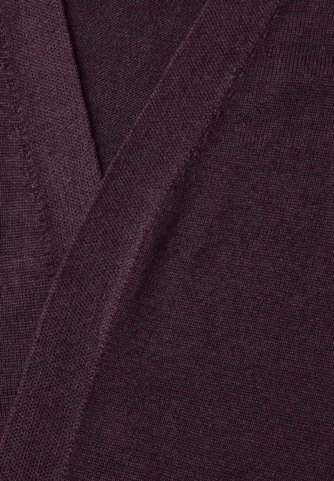 Lang openvallend vest eggplant red Nahaufnahme eines dunkelvioletten Strickstoffs mit sichtbarer Naht in V-Form.