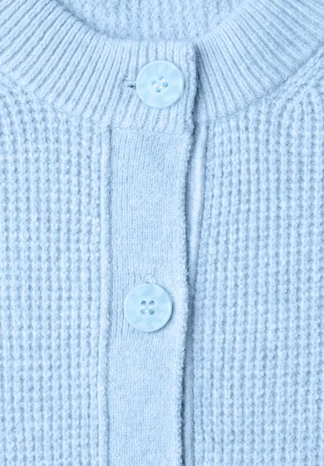 Hellblauer Strickcardigan mit Rippenmuster und zwei Knöpfen.