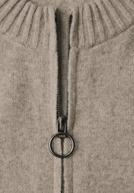 Kardigan z długimi rękawami, okrągłym dekoltem i zamkiem błyskawicznym toffee cream melange Zbliżenie beżowego swetra z dzianiny z zamkiem błyskawicznym i okrągłym uchwytem.