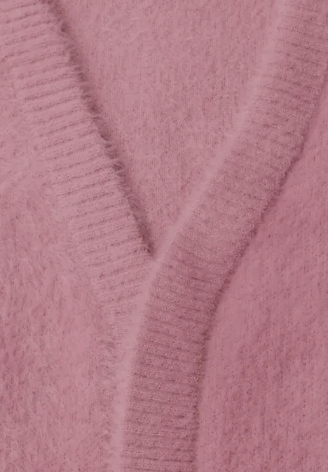 Nahaufnahme eines rosa, flauschigen Strickcardigans mit V-Ausschnitt.
