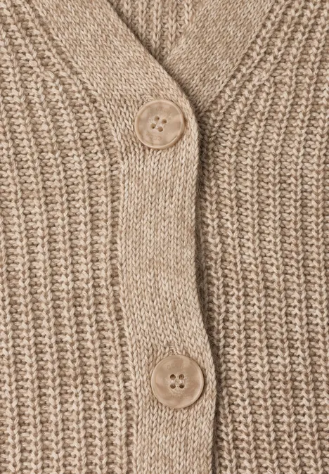 Dikke vest met V-hals en gemêleerde look creamy mocha melange Nahaufnahme eines beigen, grob gestrickten Cardigans mit zwei Knöpfen aus Holz.