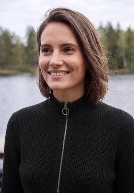 Vrouw lacht aan het water voor een bos