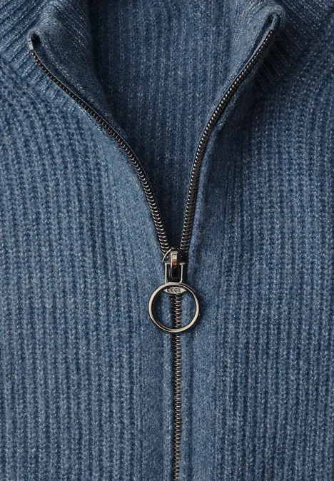 Close-up van een blauw geribbeld gebreide trui met korte ritssluiting en ringtrekker