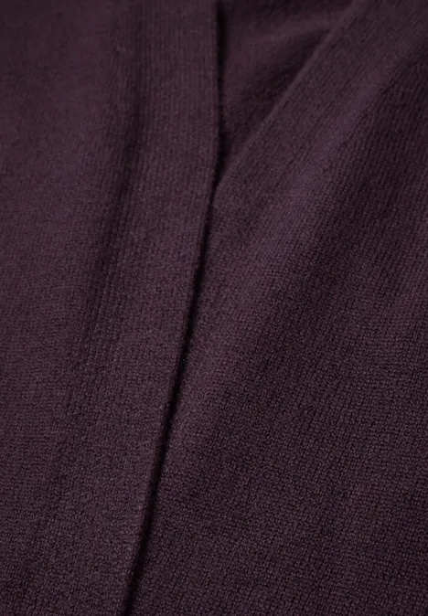 Długi kardigan o luźnym kroju eggplant red melange Zbliżenie bordowego dzianego materiału z widocznym szwem.
