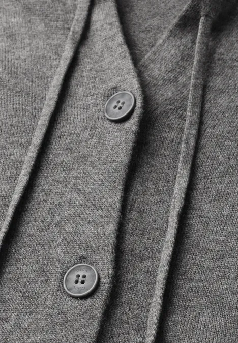 Cardigan à manches longues et à capuche flint grey melange Gros plan sur un tissu gris avec deux boutons.