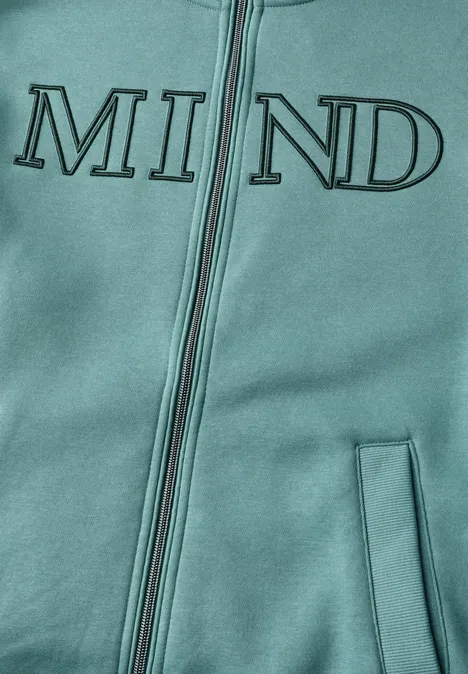 Sweatjacke mit Wording Artwork mineral blue Nahaufnahme eines türkisfarbenen Kapuzenpullovers mit Reißverschluss und dem aufgedruckten Schriftzug „MIND“.