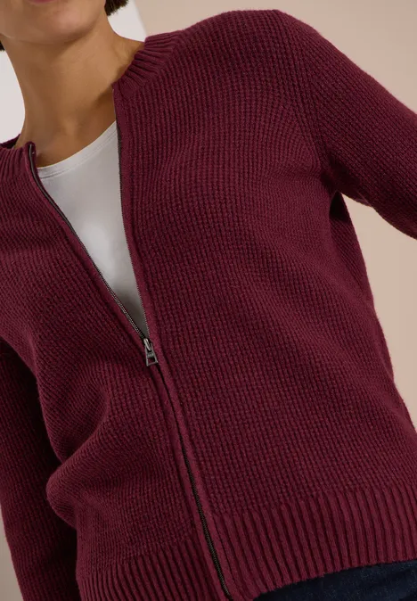 Gilet en maille bordeaux zippé, porté sur un top blanc
