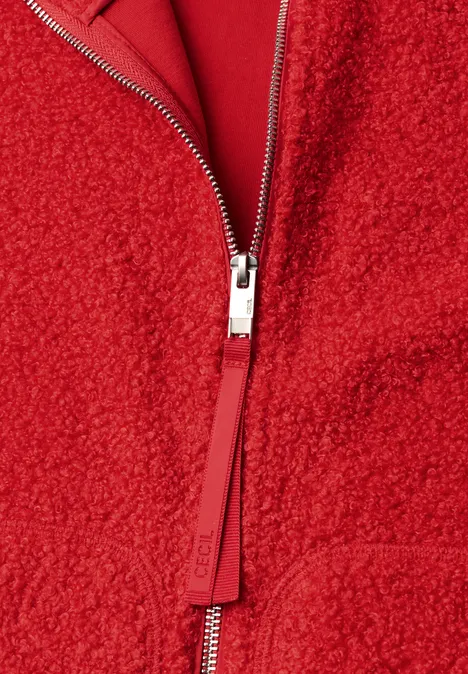Teddyjacke mit Stehkragen und Zipper flame red Nahaufnahme eines roten Kleidungsstücks mit Reißverschluss