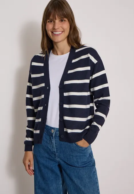 Vest met V-hals en strepen urban dark blue melange Eine lächelnde Frau trägt eine blau-weiße gestreifte Strickjacke, weißes Shirt und blaue Jeans.