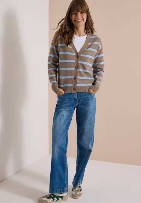 Vest met V-hals en strepen urban taupe melange Frau in weißem Top, gestreifter Strickjacke, weiten Jeans und Sneakern vor neutralem Hintergrund.