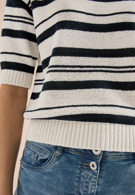 Torso in weiß-schwarzem Streifenpullover und blauer Jeanshose