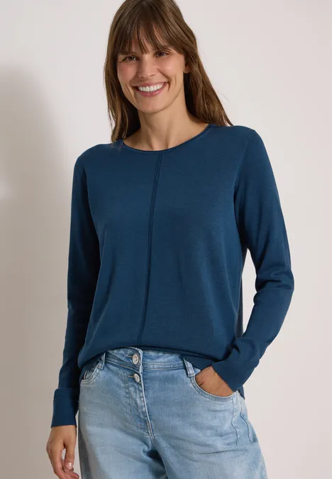 Basic Pullover mit Rundhals in Unifarbe moonlight blue Frau in dunkelblauem Pullover und hellen Jeans, lächelnd vor hellem Hintergrund.