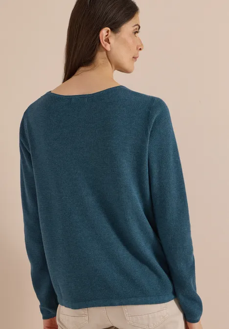 Pull à col rond et texturé dull teal blue melange Eine Frau ist von hinten zu sehen und trägt einen schlichten, blauen Pullover.