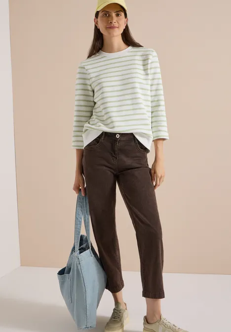 3/4-Arm Sweatshirt mit Rundhals und Streifen raw matcha lime Frau im gestreiften Langarmshirt, braunen Hosen, Sneakern und Cap mit großer hellblauer Tasche