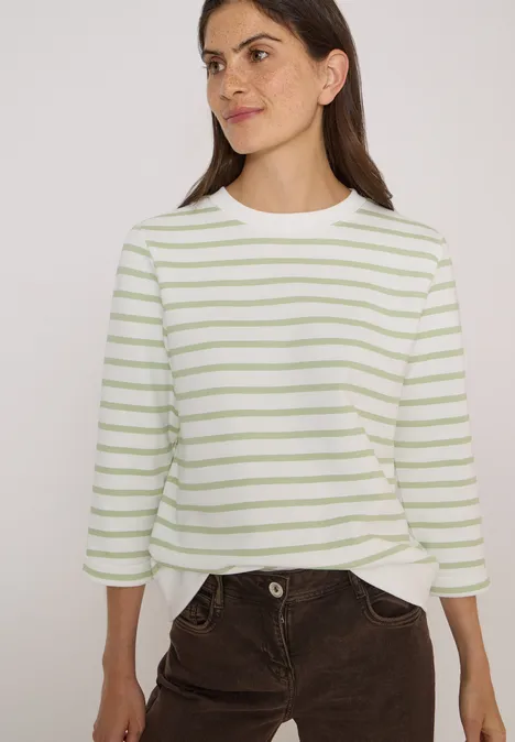 3/4-Arm Sweatshirt mit Rundhals und Streifen raw matcha lime Frau trägt weiß-grün gestreiftes 3/4-Shirt und braune Cordhose.