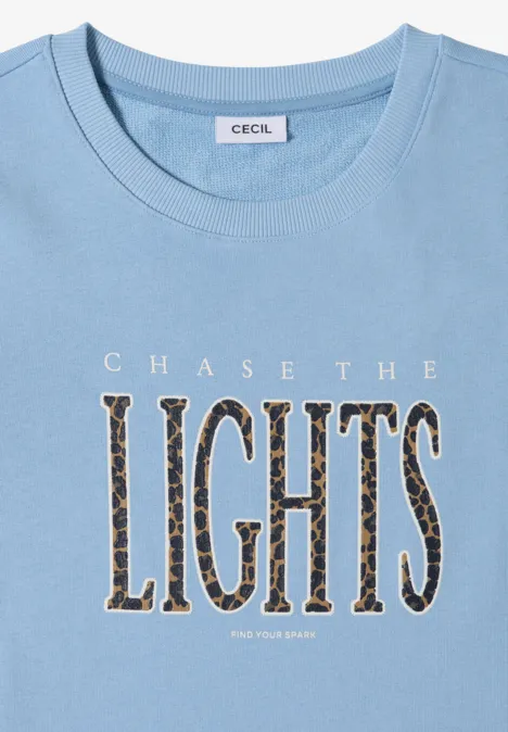 Hellblaues T-Shirt mit Aufdruck 'CHASE THE LIGHTS' in Leopardenmuster.