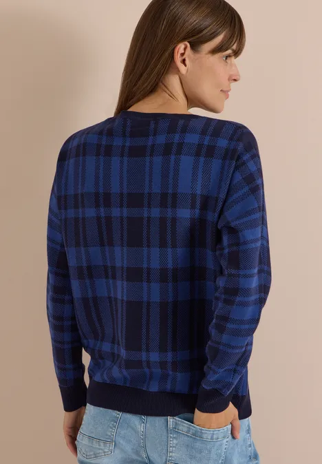 Dolman Pullover mit Karomuster urban dark blue Frau von hinten in dunkelblau kariertem Pullover und Jeans, Hände in den Taschen.