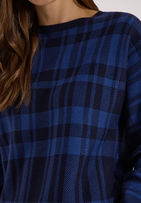 Dolman Pullover mit Karomuster urban dark blue Dame trägt blau-schwarzen karierten Strickpullover mit Rundhalsausschnitt.