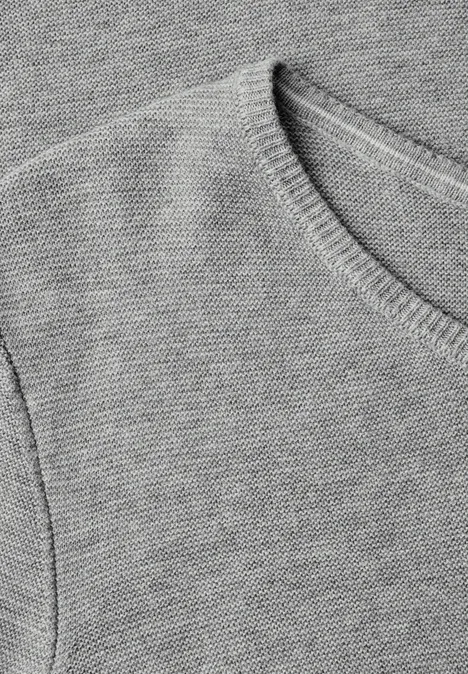 Close-up eines grauen Strickpullover-Oberteils mit Rundhalsausschnitt und feiner Rippung.