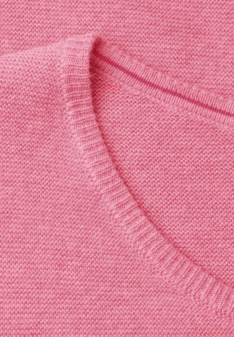 Nahaufnahme eines rosa Strickpullovers mit V-Ausschnitt