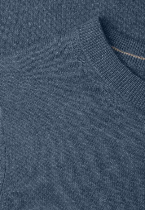 Gros plan d'un pull tricoté bleu avec encolure ronde.