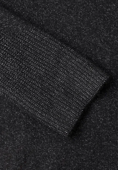 Pull col rond à textures contrastées black melange Nahaufnahme eines schwarzen, glitzernden Strickstoff-Ärmels mit Bündchen.