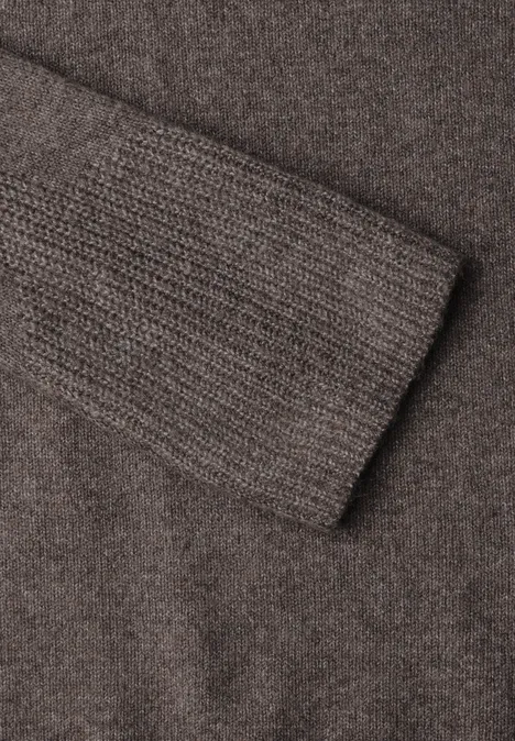 Maille brune douce avec bord-côte fin à la manche, surface texturée chaleureuse.