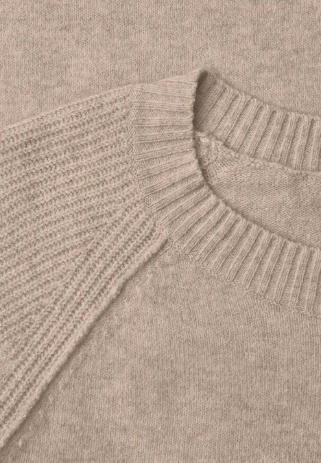Nahaufnahme eines beigen Strickpullovers mit Rundhalsausschnitt