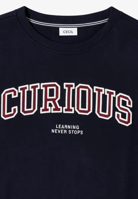 Dunkles T-Shirt mit Aufschrift 'CURIOUS' in großen Buchstaben und kleinem Text 'Learning Never Stops'.