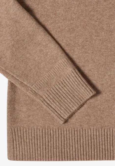 Gros plan d’un pull marron tricoté avec bords côtelés.