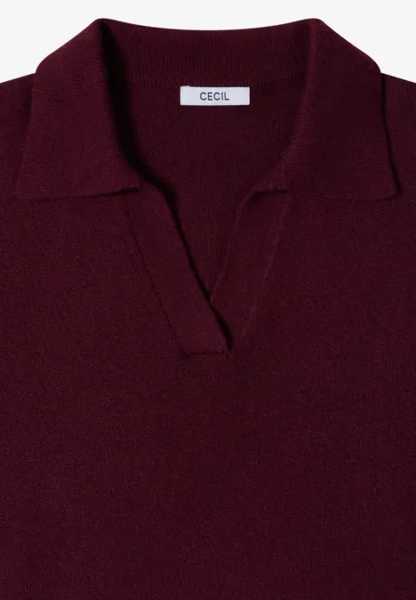 Un polo en maille bordeaux avec col et encolure en V sans boutons.