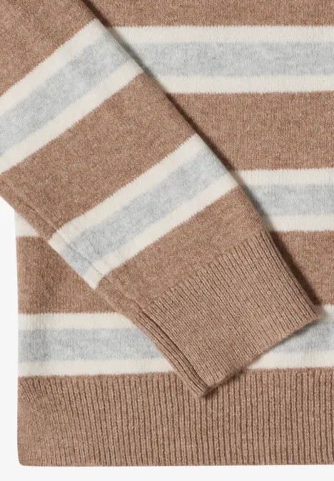 Pull beige clair à rayures horizontales blanches et bleu pâle, tricoté finement, plié.