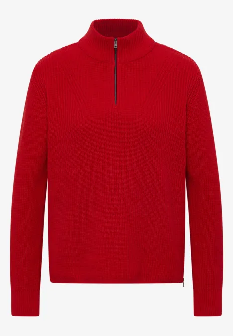 Un pull rouge à col montant, manches longues et fermeture éclair mi-longueur.
