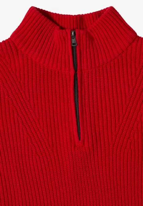 Pull rouge épais en maille grosse, col montant et demi-fermeture éclair sur le devant.
