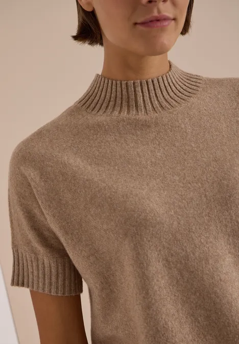 Pull beige à manches courtes en cachemire avec col roulé montant, vue rapprochée du haut du corps.
