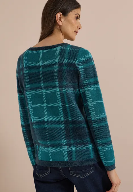 Frau von hinten in blau-grün kariertem Pullover und Jeans