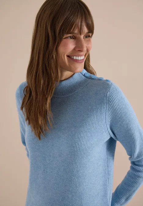 Pull texturé avec des boutons décoratifs easy blue melange Femme souriante aux cheveux bruns porte un pull côtelé bleu clair à col montant et boutons épaule.